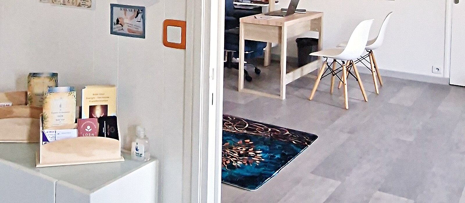 L'entrée du cabinet : la console blanche et ses brochures, la porte ouverte sur la pièce claire où se déroulent les séances